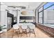 Bright kitchen featuring an island with seating, stainless steel appliances, and exposed brick near large windows at 2000 Arapahoe St # 503, Denver, CO 80205