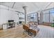 Open-concept living space boasting hardwood floors, exposed beams, and city views through large windows at 2000 Arapahoe St # 503, Denver, CO 80205
