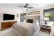 Well-lit bedroom with a ceiling fan, large bed, mounted TV, and decor including vintage skis above the headboard at 600 Cascade Dr, Golden, CO 80403
