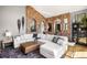 Bright living room with an exposed brick wall, white sectional couch, and snowshoe decorations at 600 Cascade Dr, Golden, CO 80403