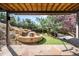 Tranquil outdoor living space with stone patio, rock waterfall, mature trees, and shaded hammock at 600 Cascade Dr, Golden, CO 80403