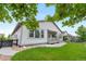 Landscaped backyard with a covered patio, lush green lawn, and charming details at 8814 S Winnipeg Ct, Aurora, CO 80016