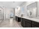 Bright bathroom featuring a double sink vanity, glass shower, and large tile flooring at 8814 S Winnipeg Ct, Aurora, CO 80016