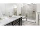 Bathroom featuring a quartz vanity top, framed mirror, glass-enclosed shower, and chrome fixtures at 8814 S Winnipeg Ct, Aurora, CO 80016