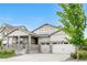 Attractive exterior featuring a covered porch, a two-car garage, and a neatly maintained yard at 8814 S Winnipeg Ct, Aurora, CO 80016