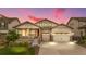 Charming home featuring a well-manicured lawn, inviting porch, and convenient two-car garage with a beautiful sunset at 8814 S Winnipeg Ct, Aurora, CO 80016