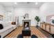 Bright living room with a decorative fireplace, plush white sofa, and stylish accents on hardwood floors at 8814 S Winnipeg Ct, Aurora, CO 80016