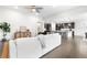 Spacious living area featuring hardwood floors, a white sofa, and a glimpse into the modern kitchen at 8814 S Winnipeg Ct, Aurora, CO 80016