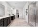 Spacious bathroom featuring double sinks, a walk-in shower, and plenty of cabinet storage at 8814 S Winnipeg Ct, Aurora, CO 80016