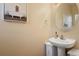 Small bathroom with pedestal sink and oval mirror at 18726 E Yale Cir # F, Aurora, CO 80013