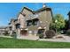 Green townhome exterior with landscaping, walkway, and a bench at 18726 E Yale Cir # F, Aurora, CO 80013