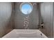 Modern bathroom features stylish tile, a soaking tub, and a circular window for natural light at 1820 S State 83 Hwy, Franktown, CO 80116