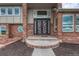 Home's entryway with a modern design front door, brick exterior, and a round window to the side at 1820 S State 83 Hwy, Franktown, CO 80116