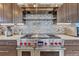 Kitchen features a stainless steel range hood, mosaic backsplash, and well-maintained cabinets at 1820 S State 83 Hwy, Franktown, CO 80116