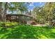 Lush backyard featuring a well-maintained lawn, mature trees, and an inviting outdoor deck for relaxation at 9113 E Evans Way, Denver, CO 80231
