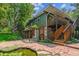 Multi-level backyard with stone patio, water feature, mature trees, and lush landscaping, perfect for outdoor living at 9113 E Evans Way, Denver, CO 80231