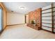Partially finished basement with brick fireplace, sliding door and adjacent built in shelving at 9113 E Evans Way, Denver, CO 80231