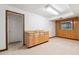 Unfinished basement with utility sink, wood paneled wall, carpet, and a door leading outside at 9113 E Evans Way, Denver, CO 80231