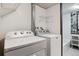 Functional laundry area with modern washer and dryer units, plus a folding rack for added convenience at 9113 E Evans Way, Denver, CO 80231