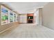 Bright living room featuring a brick fireplace, white shutters, and many large windows at 9113 E Evans Way, Denver, CO 80231