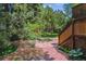 Charming outdoor patio with brick and stone pathways, surrounded by lush foliage and wooden stairs at 9113 E Evans Way, Denver, CO 80231