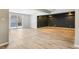 Spacious basement area with natural light, wood flooring, and black accent wall at 13071 Emerson St, Thornton, CO 80241