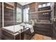 Luxurious bathroom with soaking tub, glass shower, and wooden tile accents at 13071 Emerson St, Thornton, CO 80241
