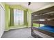 A bedroom featuring a sturdy bunk bed, bright green walls, and soft, filtered natural light at 13071 Emerson St, Thornton, CO 80241