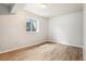 Bedroom featuring hardwood floors and a large window at 13071 Emerson St, Thornton, CO 80241