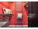 A closet with metal shelves and storage, adorned with decorative pillows against a vibrant red wall at 13071 Emerson St, Thornton, CO 80241