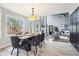 Elegant dining room with modern furnishings, large windows, and an open layout to the living area at 13071 Emerson St, Thornton, CO 80241