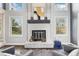 Close-up of a chic white brick fireplace with stylish decor, a black mantle, and large windows at 13071 Emerson St, Thornton, CO 80241