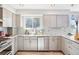 Updated kitchen with stainless steel appliances, modern cabinetry, tile backsplash, and wood-look floors at 13071 Emerson St, Thornton, CO 80241