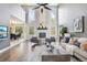 Bright and airy living room featuring a fireplace, tall windows, and an open view into the dining area at 13071 Emerson St, Thornton, CO 80241