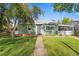 Charming single-story home features a well-manicured lawn, mature trees, and inviting walkway to the front door at 7550 Stuart St, Westminster, CO 80030
