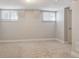 Unfinished basement with neutral carpet, two windows, and white trim offers potential for customization at 3527 W 44Th Ave, Denver, CO 80211