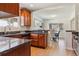 Well-lit kitchen featuring granite countertops, wood cabinets, and stainless steel dishwasher at 3527 W 44Th Ave, Denver, CO 80211