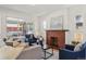 Bright living room featuring a decorative fireplace, neutral sofa, and blue accent chairs at 3527 W 44Th Ave, Denver, CO 80211
