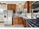 Functional kitchen with stainless steel appliances, wood cabinets, and tile floors at 2630 Albion St, Denver, CO 80207