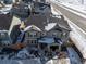 Aerial view of two-story house with grey siding, and snow on the ground at 28334 E 6Th Pl, Aurora, CO 80137