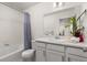 Bathroom featuring a shower with a tub, a large mirror, and a vanity sink at 28334 E 6Th Pl, Aurora, CO 80137