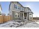 Two-story townhome with a covered porch with a traditional design and updated windows and siding on a snow day at 28334 E 6Th Pl, Aurora, CO 80137