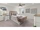 Bright main bedroom featuring a tufted headboard, neutral color palette, and contemporary ceiling fan at 28334 E 6Th Pl, Aurora, CO 80137