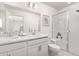 Bright bathroom featuring double sinks, white cabinetry, and a glass-enclosed shower for a clean, modern look at 28334 E 6Th Pl, Watkins, CO 80137