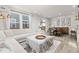 Bright living room with large windows, white sofa, dining area and modern decor, creating a cozy atmosphere at 28334 E 6Th Pl, Watkins, CO 80137