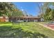 Spacious backyard with lush lawn, trees, patio area, and fenced perimeter at 6436 Otis St, Arvada, CO 80003