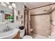 Well-lit bathroom with a tiled shower, decorative curtain, and convenient shower seating at 6436 Otis St, Arvada, CO 80003