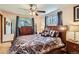 Comfortable main bedroom features a ceiling fan, window, wood floors, and an updated bedspread at 6436 Otis St, Arvada, CO 80003