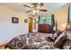 Main bedroom includes ceiling fan, windows, wood floors, dresser, and a mirror at 6436 Otis St, Arvada, CO 80003