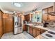 Traditional kitchen features stainless steel appliances, mosaic tile backsplash, and door to garage at 6436 Otis St, Arvada, CO 80003